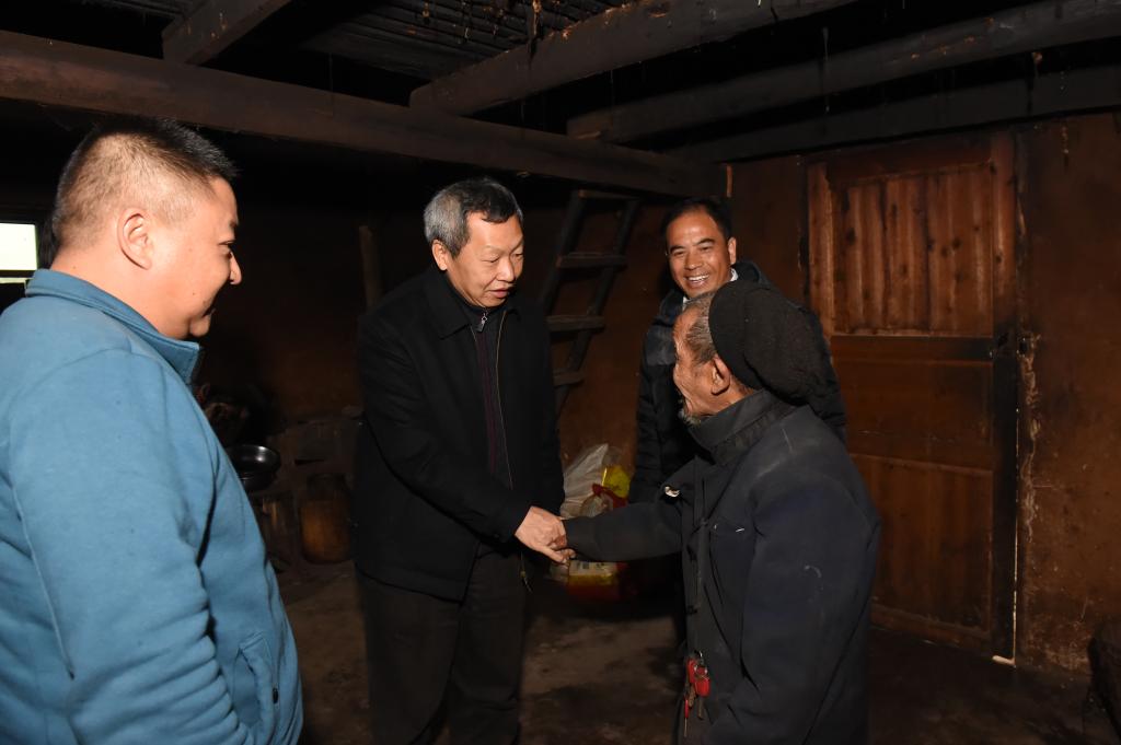图为童志云在下木树村走访建档立卡户